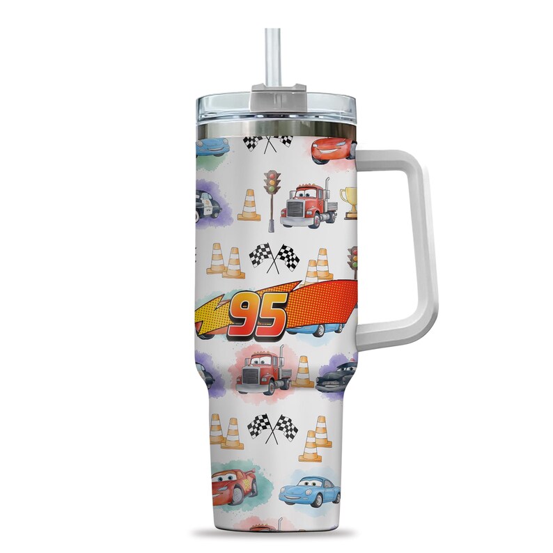 May include: A white travel mug with a handle and a straw, decorated with a pattern of race cars, traffic cones, and checkered flags. The design includes the number 95 and illustrations of various vehicles and racing elements.
