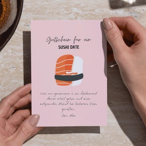 May include: A pink gift voucher with the words "SUSHI DATE" and a sushi illustration. The text below reads, "Let's go together to a restaurant of your choice and enjoy a relaxing evening with delicious food. Dein Alex."