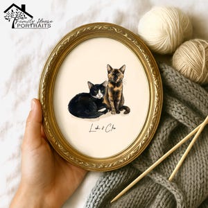 Może przedstawiać: Owalny portret w złotej ramie przedstawiający dwa koty. Jeden kot jest czarno-biały, drugi szylkretowy. Portret podpisany "Loki & Cleo". Logo Family House Portraits znajduje się w lewym górnym rogu.
