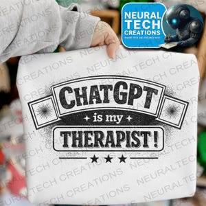 May include: White sweatshirt with the text "CHATGPT is my THERAPIST!" in a black, distressed font. The design includes star accents and a geometric design on each side. The sweatshirt is held by a person.