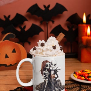 May include: White ceramic mug with a graphic of Jack Skellington and Sally from The Nightmare Before Christmas. The mug is filled with whipped cream and a cinnamon stick.