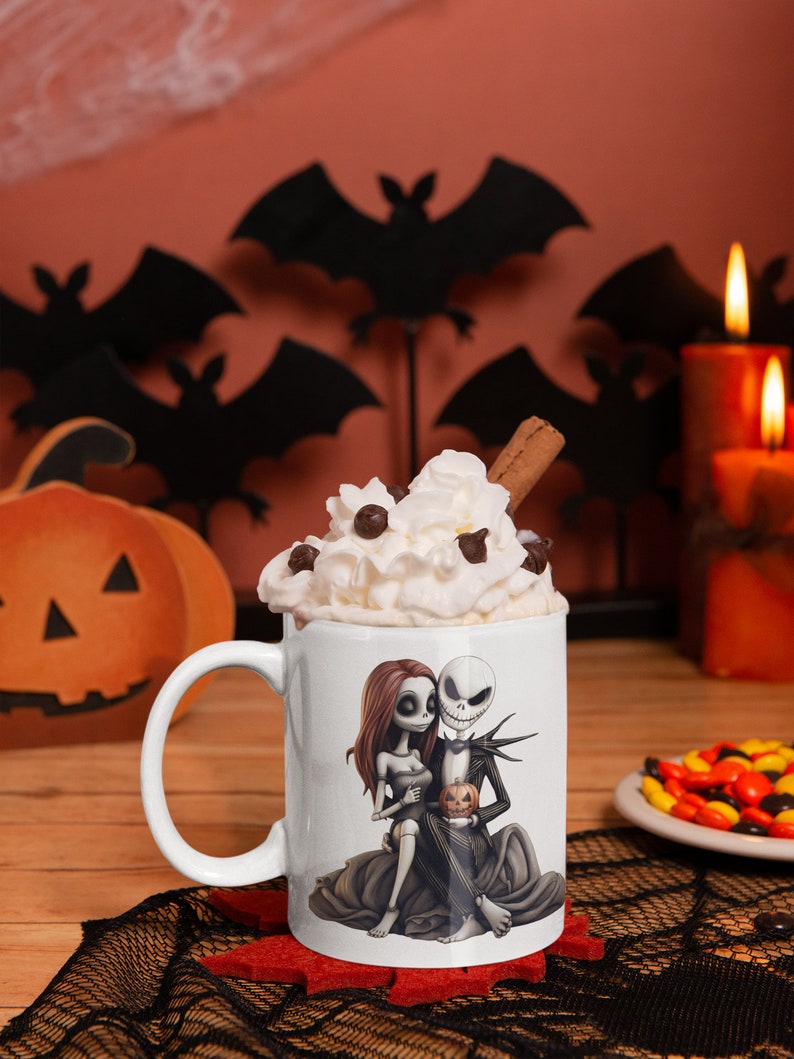 May include: White ceramic mug with a graphic of Jack Skellington and Sally from The Nightmare Before Christmas. The mug is filled with whipped cream and a cinnamon stick.