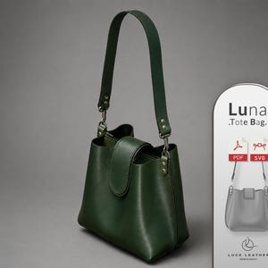 Puede incluir: Un bolso tote de cuero verde oscuro con una sola correa para el hombro, cierre de solapa y herrajes de metal plateado. Junto al bolso hay un letrero vertical con la etiqueta Luna Tote Bag, iconos PDF y SVG y el texto Luce Leather.