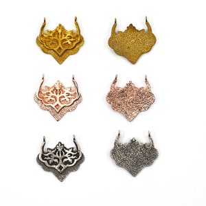 May include: Set of six metal clasps in gold, rose gold, and silver finishes. Each clasp features a detailed tree design.