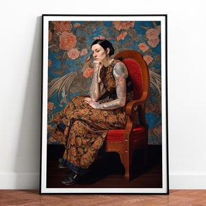 Puede incluir: Impresión artística enmarcada que muestra a una persona sentada en una silla roja, con un vestido estampado y tatuajes en los brazos. El fondo es un papel pintado floral en tonos azules y turquesas.