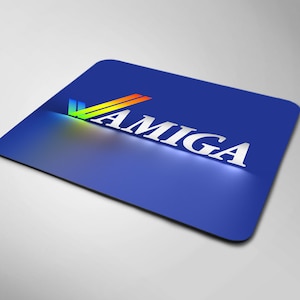 Può includere: Un tappetino per mouse rettangolare blu con la parola "AMIGA" in lettere bianche e un logo a forma di segno di spunta color arcobaleno.