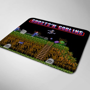 May include: A black and green mouse pad with a pixelated image of a video game character and the text "Ghosts 'n Goblins".