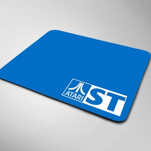Könnte beinhalten: Ein blaues Mauspad mit dem Atari-Logo und den Buchstaben "ST" in Weiß.
