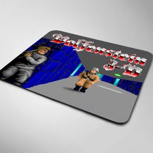 Puede incluir: Alfombrilla de ratón rectangular con un diseño de videojuego retro. La alfombrilla muestra el título del juego "Wolfenstein 3-D" en una fuente 3D roja y plateada. El gráfico incluye dos personajes y un fondo azul y gris.