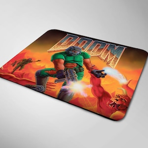 May include: A green and black mousepad with a graphic of a video game character holding a gun. The character is standing in front of a red and orange background with the word "DOOM" in large letters.