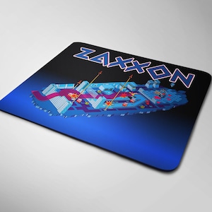May include: A blue and black mousepad with a pixelated image of a video game level and the text "ZAXXON" in a stylized font.