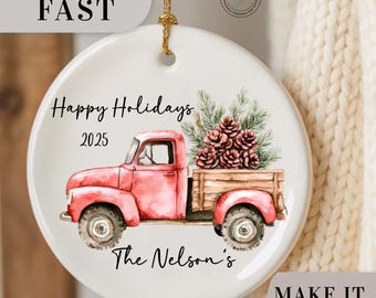 May include: A white ceramic Christmas ornament with a red vintage truck carrying pinecones. The ornament has the text "Happy Holidays 2025" and "The Nelson's". A gold string is attached for hanging.