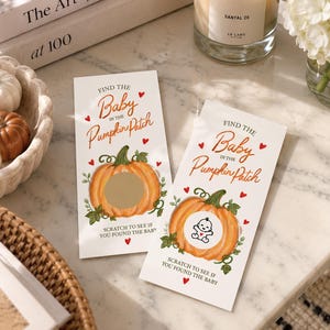 May include: Two rectangular game cards titled Find the Baby in the Pumpkin Patch with orange pumpkin illustrations. One card features a gold scratch-off circle, while the other shows a revealed black and white baby icon. Red hearts decorate the white cards.