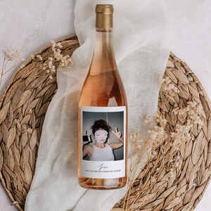 Op de afbeelding: Een fles ros&eacute; wijn met een gepersonaliseerd etiket met een foto van een vrouw en de tekst "Josie, Wil je mijn bruidsmeisje zijn?"