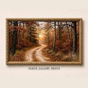 May include: A rectangular landscape painting in a decorative gold frame depicting a dirt path winding through a forest during autumn. The scene features orange and brown foliage, tall trees, and a soft sunset glow. The text NORTH GALLERY PRINTS appears below.