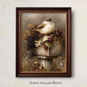 May include: A framed wall art print featuring a small, fluffy bird perched atop a weathered mailbox. The mailbox is adorned with autumn leaves and dark berries. A circular logo with a deer silhouette and the text NGP is visible in the corner.