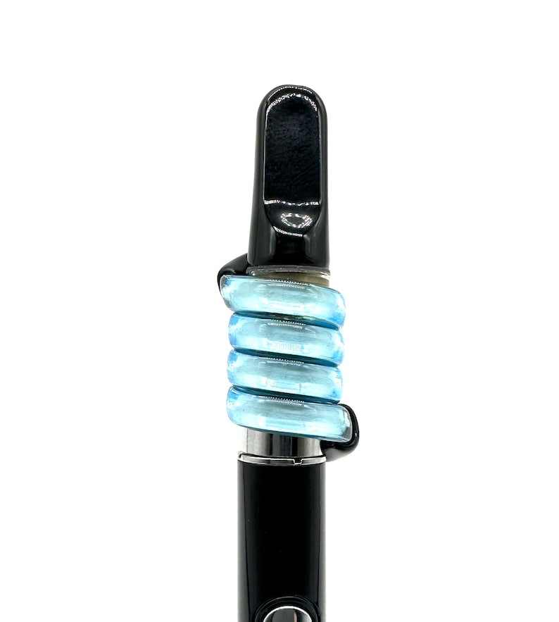May include: A black vape pen with a blue silicone mouthpiece. The mouthpiece is made of multiple rings that are stacked on top of each other.