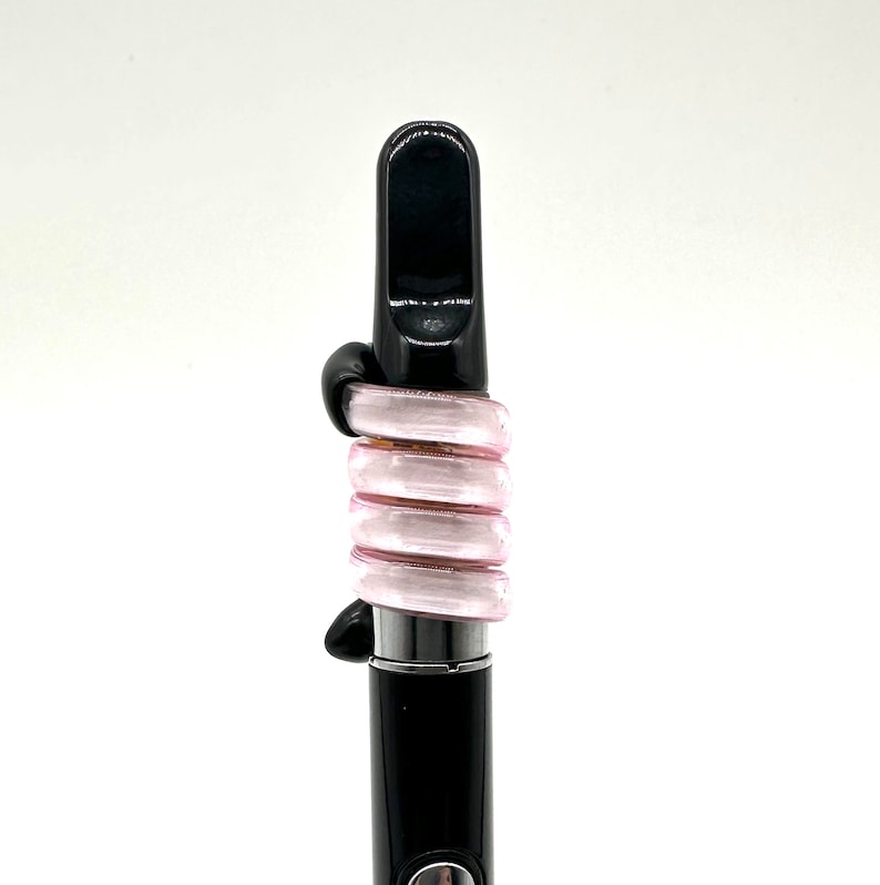 May include: A black and pink glass vape pen with a mouthpiece and a coil.