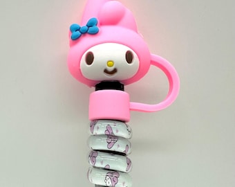 May include: A pink and white cartoon character-themed accessory. The character has a pink head with a blue bow, white face, and a small yellow nose. The accessory is attached to a silver metal tube with patterned rings.