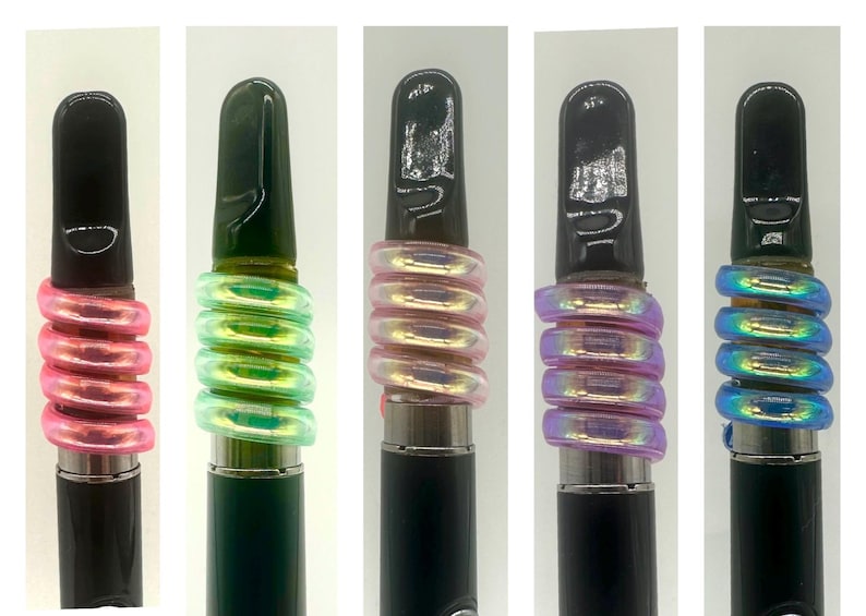 May include: Five different colored vape pens with a black mouthpiece and a spiral iridescent band around the middle of the pen.