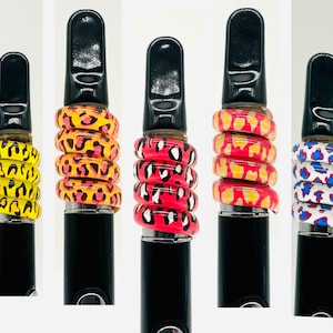 May include: Five black vape pens with different colored animal print designs. The designs are yellow, orange, red, pink, and blue.
