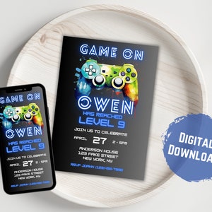 Peut inclure: Une invitation num&eacute;rique &agrave; t&eacute;l&eacute;charger pour une f&ecirc;te d'anniversaire. L'invitation pr&eacute;sente une manette de jeu vid&eacute;o bleue et verte avec le texte "Game On" et "Owen Has Reached Level 9". L'invitation comprend &eacute;galement la date et l'heure de la f&ecirc;te, l'adresse et un num&eacute;ro de RSVP.