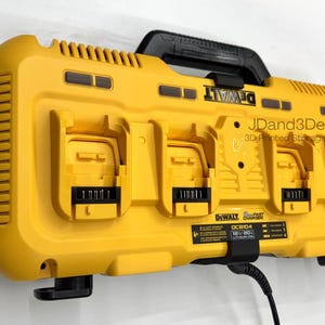 May include: A yellow and black DeWalt battery charger with four charging ports. The charger has a black handle and the DeWalt logo is visible. The text "JDand3Designs 3D Printed Storage Solutions" is also visible.