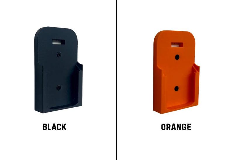 May include: Two wall-mounted holders, one black and one orange, are displayed against a white background. Each holder has a rectangular shape with a curved top and a small shelf. The word "BLACK" is below the black holder, and "ORANGE" is below the orange holder.