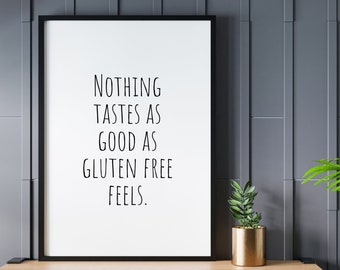 May include: Black and white text on a white background in a black frame. The text reads "Nothing tastes as good as gluten free feels." The image is on a wooden surface with a green plant in a gold pot.