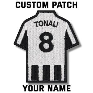 Puede incluir: Un parche personalizado con forma de camiseta de fútbol. La camiseta es blanca con detalles negros, el número 8 y el nombre TONALI. El parche también incluye el texto "CUSTOM PATCH" y "YOUR NAME".