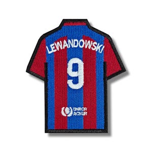 Può includere: Maglia da calcio a strisce rosse e blu con il nome "LEWANDOWSKI" e il numero "9" sul retro. La maglia ha anche un piccolo logo bianco in basso.
