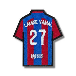 Può includere: Toppa per maglietta da calcio a strisce rosse e blu con il nome "Lamine Yamal" e il numero "27" ricamato in bianco. La toppa include anche il logo dell'UNHCR.