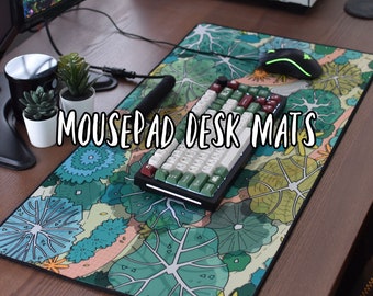 May include: A large, colorful desk mat with a leafy pattern. The mat features a keyboard and mouse, and the text "Mousepad Desk Mats" is printed on the mat.