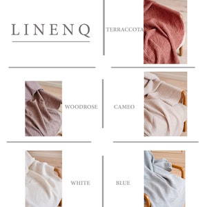 May include: A set of six waffle weave linen throw blankets in various colors, including terracotta, woodrose, cameo, white, and blue. The blankets are folded and displayed on a wooden chair.