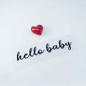 iron on transfer decal with the text hello baby write on black