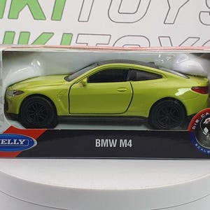 May include: A die-cast metal BMW M4 scale model car in a box. The car is a bright yellow-green colour with black wheels and a black roof. The box has the Welly logo and the text "BMW M4".
