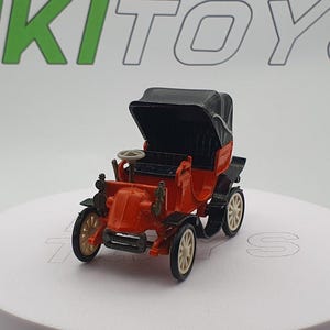 Könnte beinhalten: Ein rotes Spielzeugauto mit einem schwarzen Stoffdach. Das Auto hat vier Räder und ein Lenkrad. Das Auto ist ein Vintage-Modell.