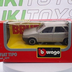May include: A silver Fiat Tipo model car in a red and yellow box. The box features the Burago logo and the text "FIAT TIPO" and "cod. 4179". The car is a miniature replica of a station wagon.