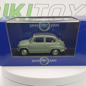 May include: A miniature Fiat 600 model in a blue box. The car is painted in a light green colour with a black roof. The box features the text "1899 FIAT 1999".