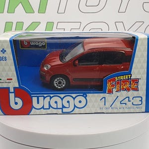 May include: A red die-cast metal Burago model car in a box. The box is blue and white with the words "Street Fire" and "1/43" printed on it. The car is a small, red hatchback.