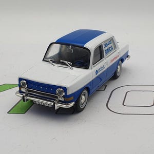 Può includere: Un modello di auto giocattolo bianco e blu di una Simca 1000, con il testo "DESAROLLO SIMCA ASISTENCIA" sul lato. L'auto ha un tetto blu e una carrozzeria bianca con una striscia blu che corre lungo il lato. L'auto ha una targa che recita "M-375733".