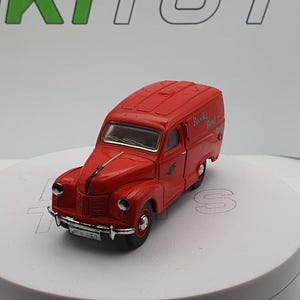 May include: Red toy van with "Brooks Bread" written on the side. The van has a white roof and a black grill.