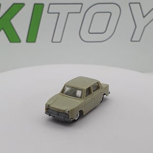 Puede incluir: Un modelo de coche de juguete de color beige con una parrilla delantera y faros detallados. El coche tiene un parabrisas negro y ruedas negras.