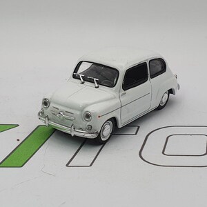 Può includere: Modello di auto giocattolo bianco di un'auto europea classica con interni neri. L'auto ha uno stile di carrozzeria arrotondato e una piccola griglia.