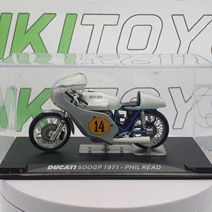 Könnte beinhalten: Ein silbernes Ducati 500GP Motorradmodell aus dem Jahr 1971 mit der Nummer 14 an der Seite in einer transparenten Vitrine. Das Motorrad ist eine Nachbildung des von Phil Read gefahrenen Motorrads.