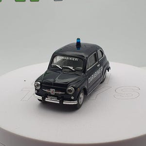 Op de afbeelding: Zwarte, gegoten modellauto van een Fiat 500 met een blauw zwaailicht op het dak. De auto heeft "CARABINIERI" op de zijkant en "CARABINIERI" op de achterkant.