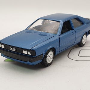 May include: A blue toy car model of an Audi 80, a compact car manufactured by Audi from 1972 to 1996.