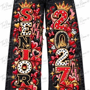 May include: Black denim jeans featuring a vibrant graphic print on the legs. The left leg displays the word SENIOR in stylized letters, while the right leg shows the year 2027. The design includes red bows, hearts, crowns, and castle silhouettes.