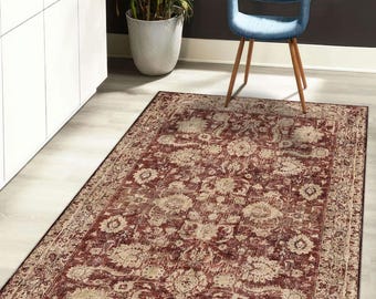 May include: A rectangular rug with a distressed, vintage look. The rug features a deep red background with a floral pattern in cream and beige. The border is a darker red, and the rug is placed on a light-colored wooden floor.