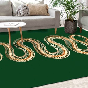 Può includere: Un tappeto verde con un designo a scheletro di serpente dorato. Il tappeto è in un soggiorno con un divano e un tavolino.